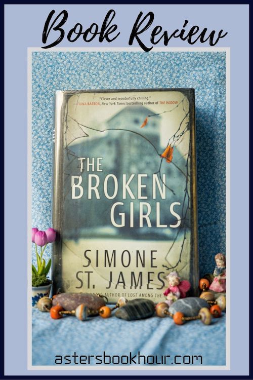 The pinterest image for The Broken Girls by Simone St. James book review. There is a blue floral print background with the novel centered in the middle and the cover facing the front.