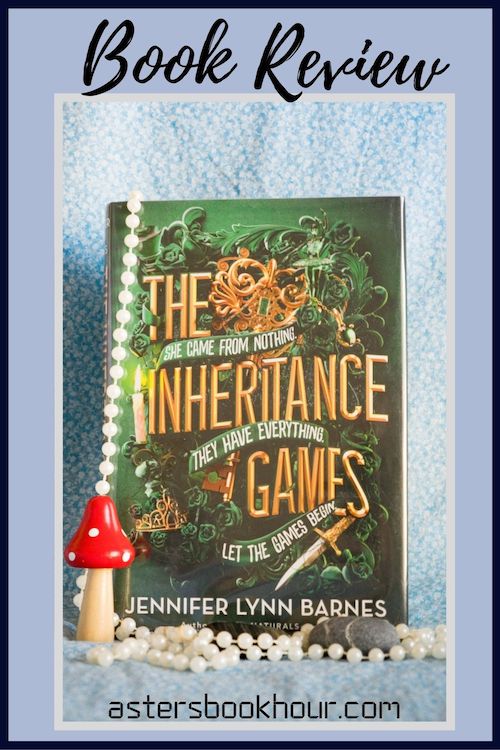 The pinterest image for The Inheritance Games by Jennifer Lynn Barnes book review. There is a blue floral print background with the novel centered in the middle and the cover facing the front.