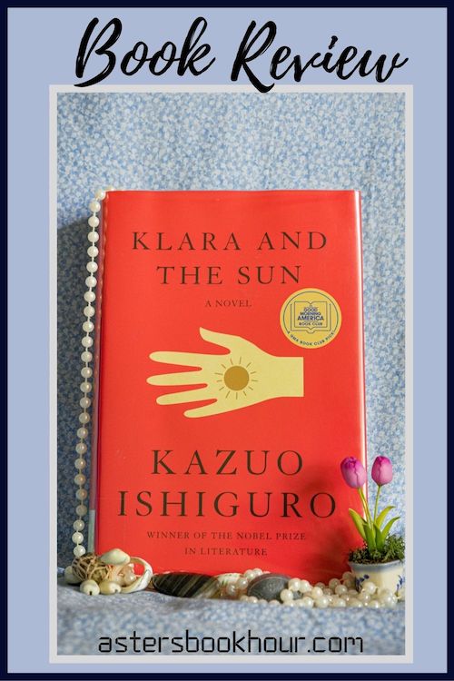 The pinterest image for Klara and the Sun by Kazuo Ishiguro book review. There is a blue floral print background with the novel centered in the middle and the cover facing the front.