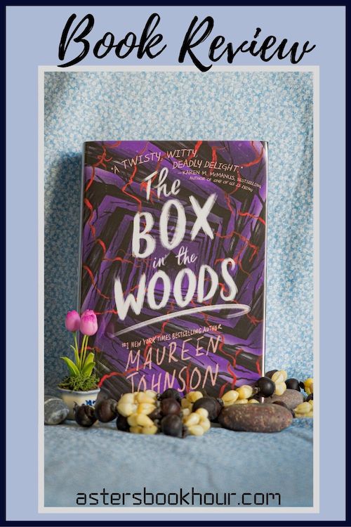The pinterest image for The Box in the Woods by Maureen Johnson book review. There is a blue floral print background with the novel centered in the middle and the cover facing the front.
