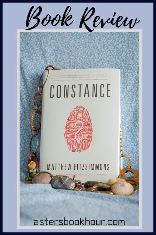 The pinterest image for Constance by Matthew FitzSimmons book review. There is a blue floral print background with the novel centered in the middle and the cover facing the front.