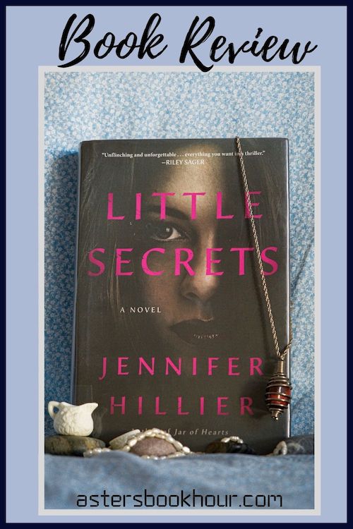 The pinterest image for Little Secrets by Jennifer Hillier book review. There is a blue floral print background with the novel centered in the middle and the cover facing the front.