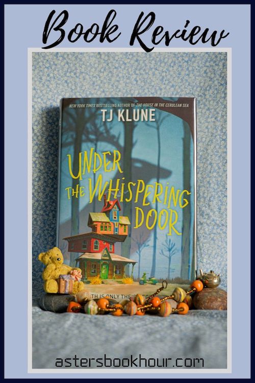 The pinterest image for Under the Whispering Door by TJ Klune book review. There is a blue floral print background with the novel centered in the middle and the cover facing the front.