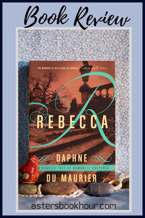 The pinterest image for Rebecca by Daphne du Maurier book review. There is a blue floral print background with the novel centered in the middle and the cover facing the front.