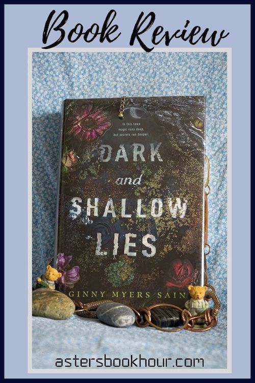 The pinterest image for Dark and Shallow Lies by Ginny Myers Sain book review. There is a blue floral print background with the novel centered in the middle and the cover facing the front.