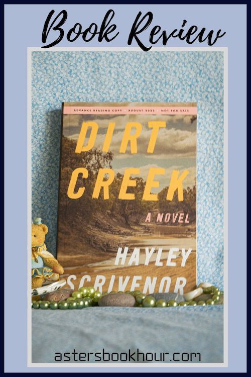 The pinterest image for Dirt Creek by Hayley Scrivenor book review. There is a blue floral print background with the novel centered in the middle and the cover facing the front.