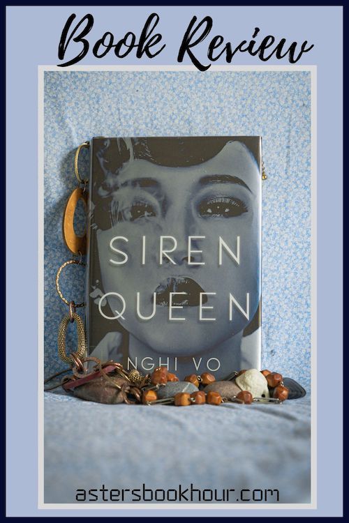 The pinterest image for Siren Queen by Nghi Vo book review. There is a blue floral print background with the novel centered in the middle and the cover facing the front.