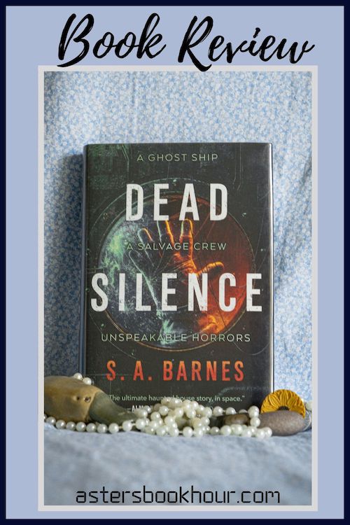 The pinterest image for Dead Silence by S.A. Barnes book review. There is a blue floral print background with the novel centered in the middle and the cover facing the front.