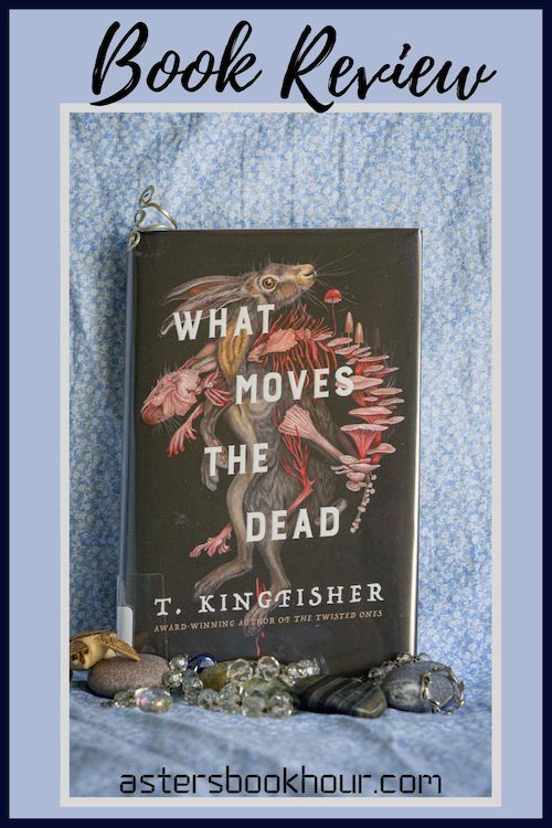 The pinterest image for What Moves the Dead by T. Kingfisher book review. There is a blue floral print background with the novel centered in the middle and the cover facing the front.