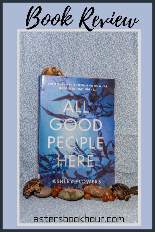 The pinterest image for All Good People Here by Ashley Flowers book review. There is a blue floral print background with the novel centered in the middle and the cover facing the front.